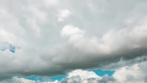 Big White Clouds are Flying on a Summer Blue Sky in Timelapse alt