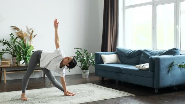 A Young Indian Woman Does Morning Yoga, Does A Body Stretching Exercise, Stands on the Floor alt