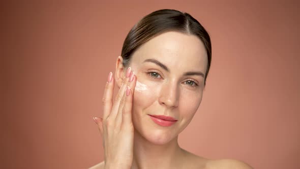 Woman Applying Cosmetic Product on Face