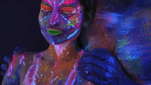 Couple with UV Drawings on the Skin in the Dark Under Light of Fluorescent Lamps