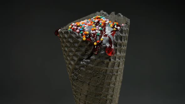 Gray Ice Cream in a Black Waffle Cone on a Black Background Rotates