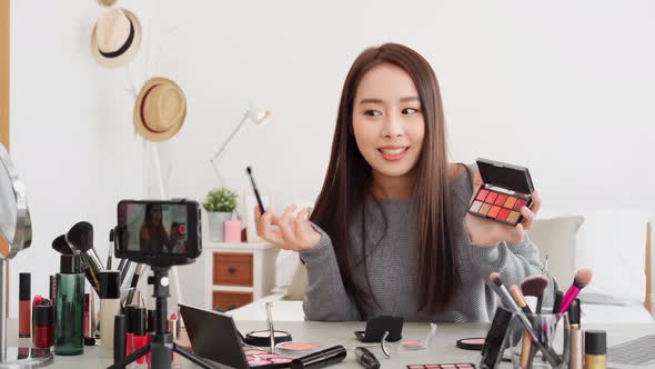 Young beautiful Asian woman professional beauty influencer doing cosmetic makeup tutorial online