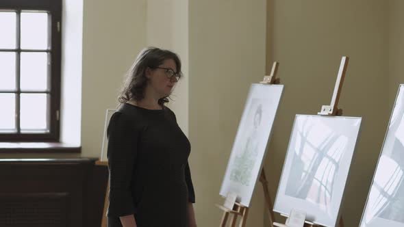 Pregnant Woman in Glasses Visits Art Gallery alt