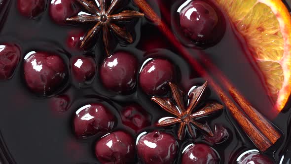 Mulled red cherry wine or punch with slice of orange and anise star and cinnamon alt