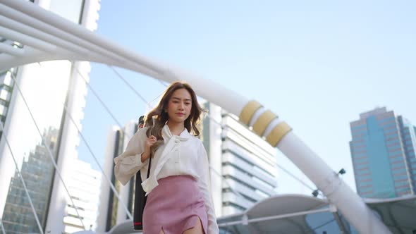 4K Asian business woman walking down staircase at railway station in the morning alt