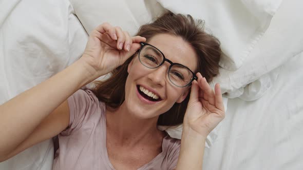 Woman in Glasses Lying in Bed
