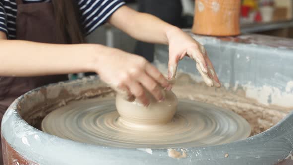 Little Girl Is Molding at Pottery Wheel Creating a Clay Bowl, Dirty Kid's Hands.