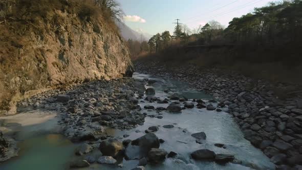 Aerial shot flying over the Rhone river winding through the town of Lavey Les Bains, Switzerland. alt