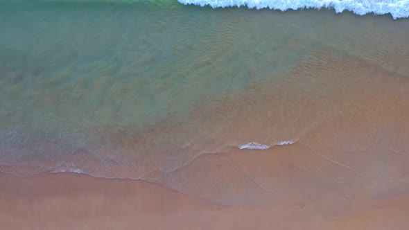 Aerial Top View Smooth Waves On White Sand Beach. alt