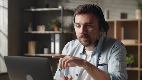 Concentrated Young Male Worker Employee Entrepreneur in Headphones Holding Negotiations Meeting alt