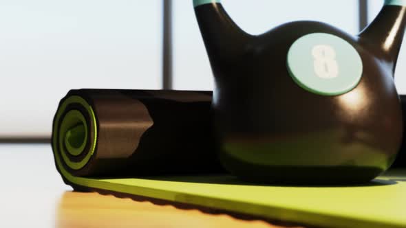 Fitness Equipment: Kettlebell, dumbbells and erobic step on a green yoga mat.