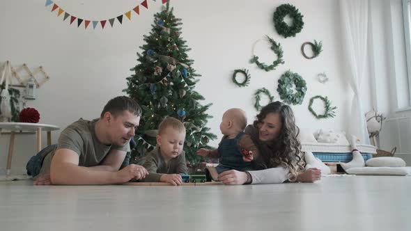 Family of Four Spending Time Over Christmas Tree alt
