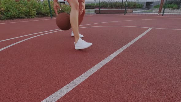 Female Basketball Player Dribbling on City Playground. Ball Is Jumps, Bounce. White Sneakers alt