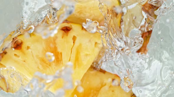 Super Slow Motion Shot of Pineapple Slices Falling Into Water Whirl at 1000 Fps alt