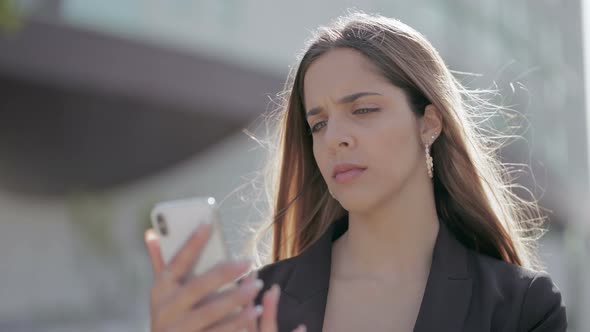 Cheerful Young Woman Using Smartphone on Street alt