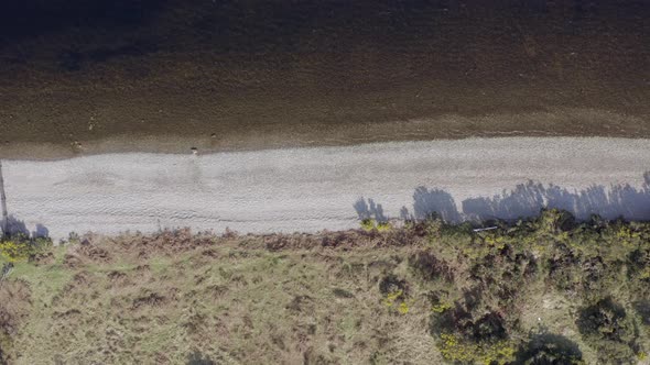 Bird's Eye View of Empty Pebble Shores of a Lake Aerial Flyover alt