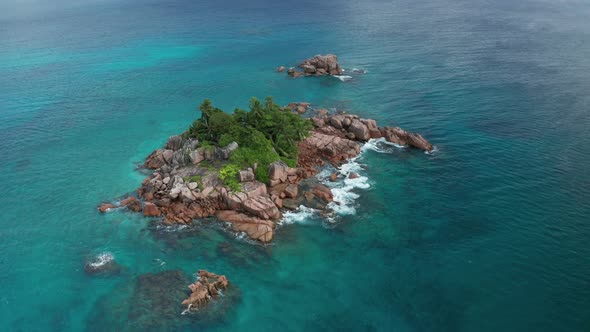 Aerial arc shot around small oasis desert island St. Pierre, Praslin alt