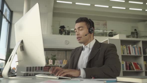 Customer Support Operator with Handsfree Headset Working in the Office in a Business Suit alt