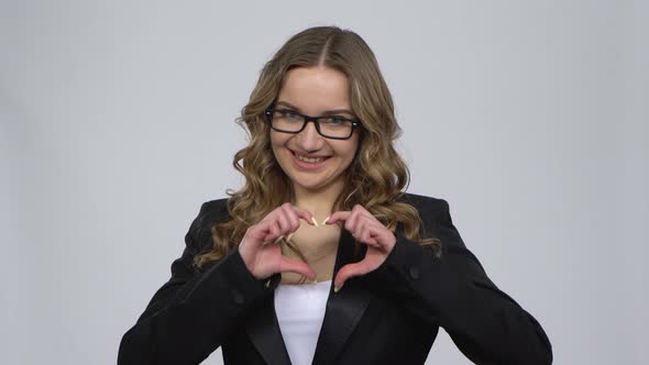 Sexy Woman Flirting Is Showing Heart with Fingers and Blowing Kiss alt