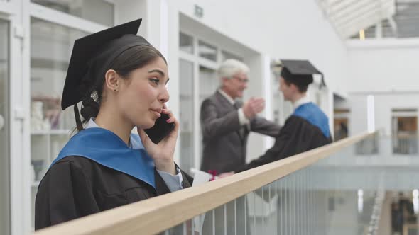 Cheerful Female Graduate Having Phone Call alt