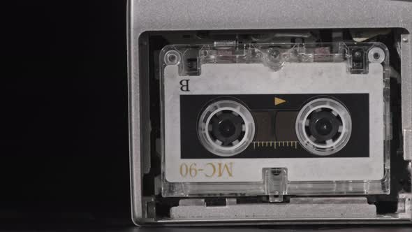 Vintage Audio Tape with a Blank Label Spinning in Cassette Recorder Closeup alt