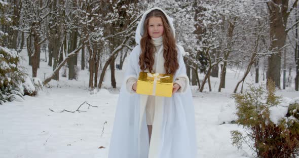 A Girl In The Form Of An Angel Rides Through A Snowy Forest And Carries A Gift. Christmas Fairy Tale