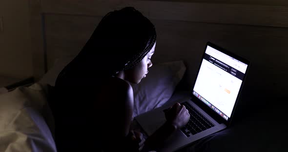 Woman using laptop at night.