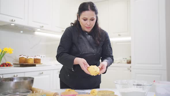 a Woman Cook Lays Out Dough in Paper Molds for Baking Easter Cakes alt