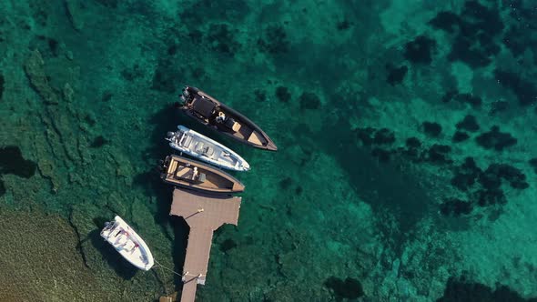 Motor boats moored at pier among sea turquoise water