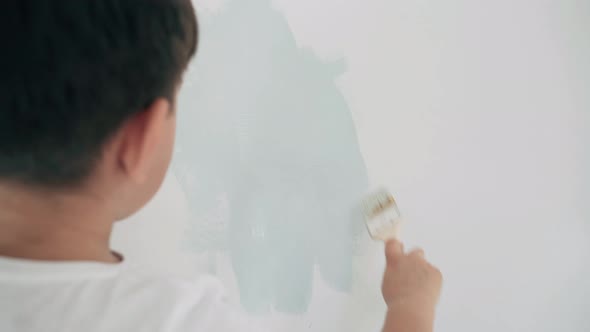 Caucasian Boy Paints White Wall Boy Makes House Repairs Boy Paints Blue Paint Close Up