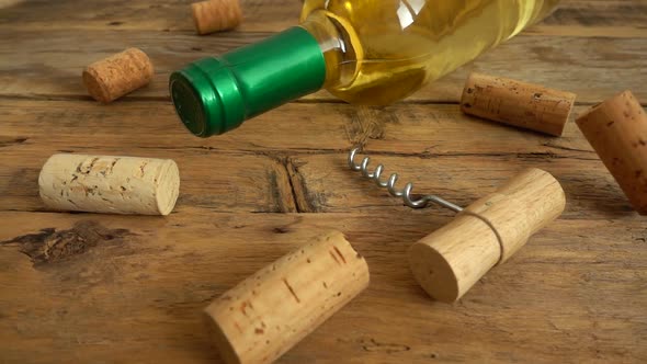 Wine bottles on an old vintage wooden board and falling corks alt