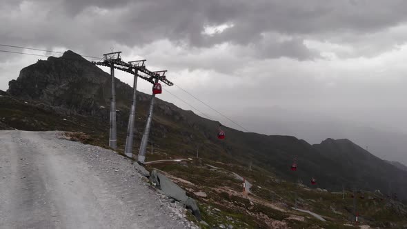 Red Aerial Tramway Against Gloomy Sky At Kitzsteinhorn Alps In Kaprun, Austria. - Aerial Shot alt