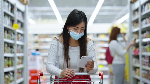 Asian Customer in Mask with Shopping List at Store alt