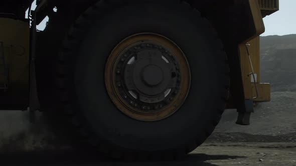 Giant Mining Truck Drives Past the Camera to Excavator for Loading alt