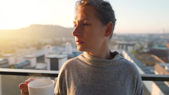 Woman Starts Her Day with a Cup of Tea or Coffee and Checking Emails in Her Smartphone on the alt