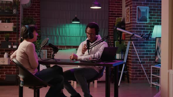 African American Podcaster Introducing Guest to Listeners in Evening Online Show Broadcast alt