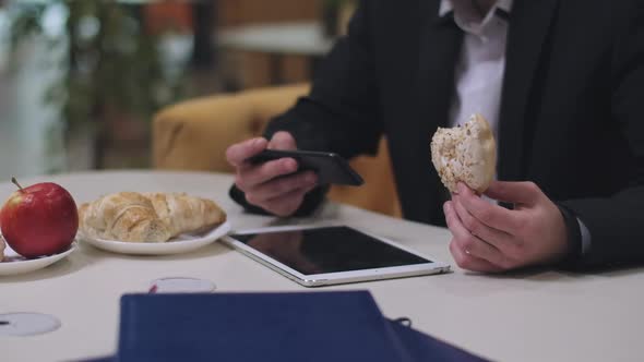 Sweet Delicious Doughnut in Male Caucasian Hand with Unrecognizable Man Messaging Online on alt