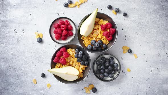 Golden Cornflakes with Fresh Fruits of Raspberries Blueberries and Pear in Ceramic Bowl