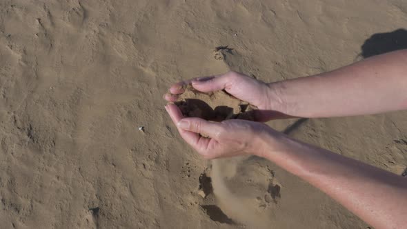 Picking up sahara sand in Morocco and letting it slip through his fingers. alt