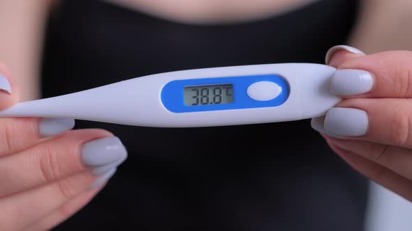 Close Up: Woman Holding Digital Medical Thermometer with High Temperature
