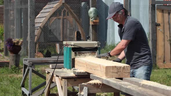 Carpenter planing wooden beam