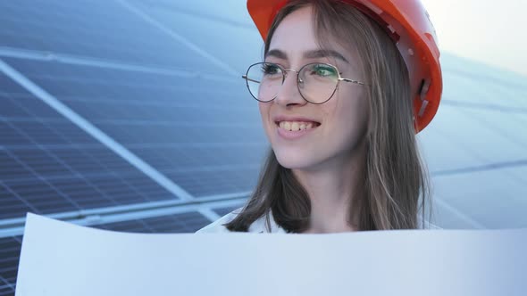 Handsome Architect Woman Examining a Draft Map or Blueprint Project Plan alt