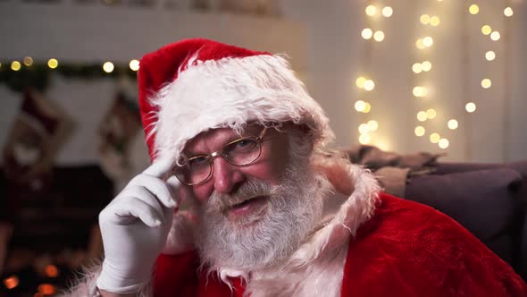 Portrait Funny Santa Claus in Glasses Sitting in His Rocker Near Christmas Tree. Christmas Spirit