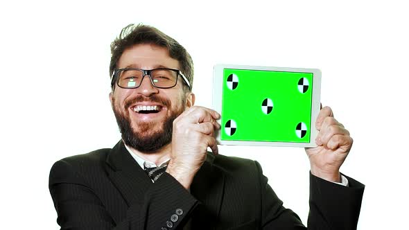 A Conceptual Mockup. Bearded Businessman with Glasses Holding a Tablet with a Green Screen. alt