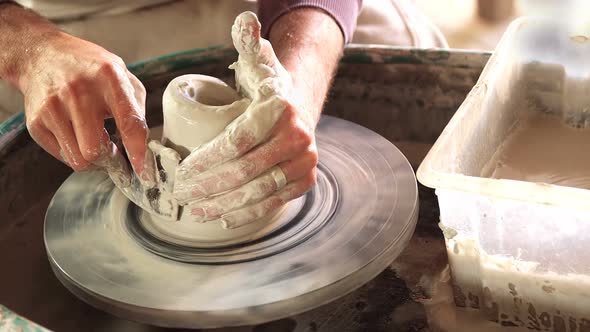 Mid section of potter making pot alt