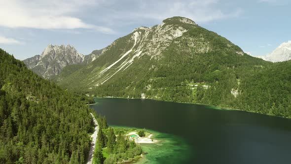 Aerial view of Lago del Predil lake surrounded by hills in Itally. alt