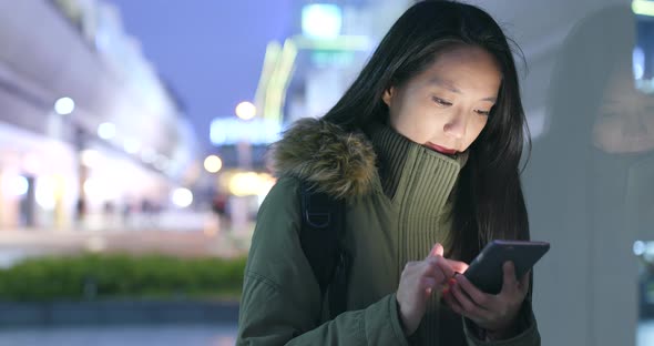 Asian woman use of mobile phone in city at night alt