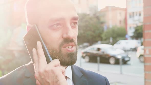Portrait of Business Person Talking on the Phone with the Sun Behind Him alt