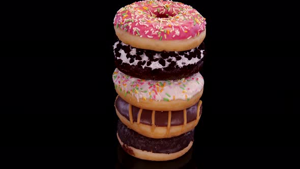 Donuts with icing and colorful sprinkle a black background. Sweet doughnut with chocolate frosting