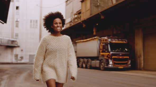 Smiling Young Woman With Afro Hair Walking Passed alt